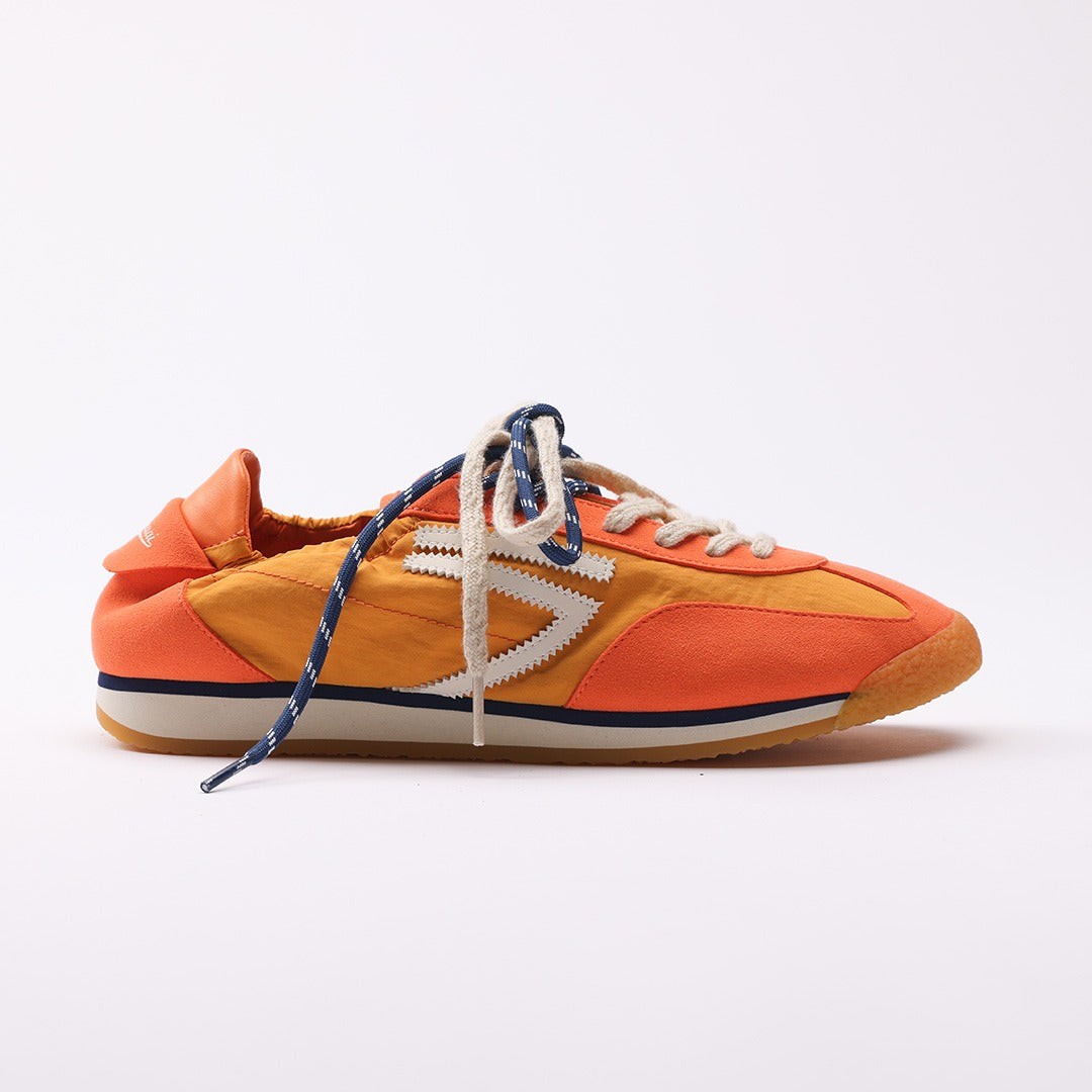 Orange vegan sneakers by Puraai, crafted from recycled nylon and microsuede in Marche, Italy. Featuring a vintage athletic silhouette with blue and beige double laces for a refined lifestyle look.