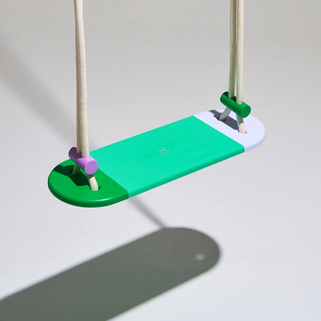 Contoured solid wood swing with green rope. Ethical handmade outdoor toy inspired by the Hungarian landscape.