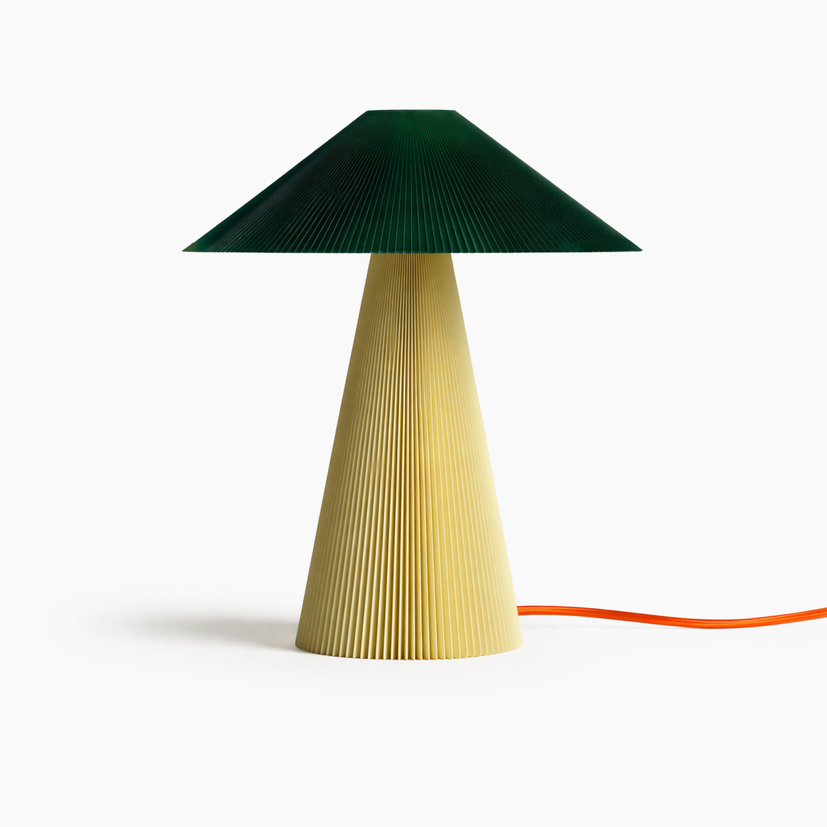 The Jane Teen table lamp by Manu Matters with a dark green ribbed base and an off-white shade. A sustainable 3D-printed design made from recycled plastic bottles.