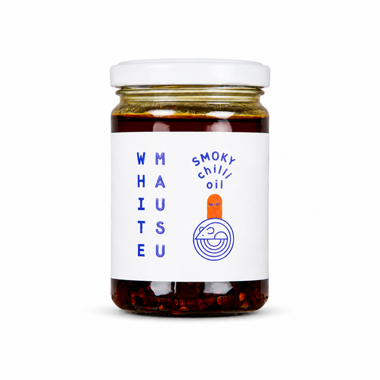A jar of White Mausu Smoky Chilli Oil. A vegan and gluten-free condiment featuring a blend of chillies, garlic, and spices in a recyclable jar.